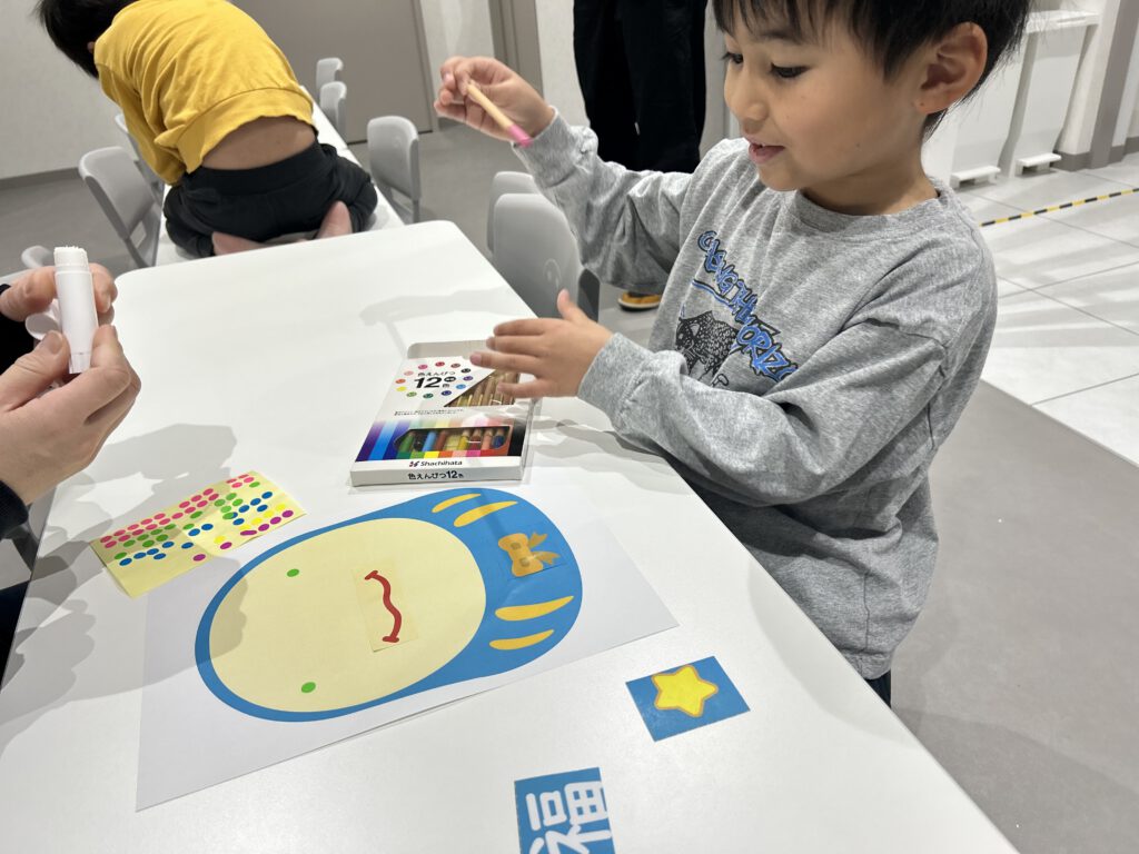 塗り絵とシール貼りを共同でしている様子